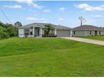 Single-story house with gray garage and green lawn at 2318 N Chamberlain Blvd, North Port, FL 34286