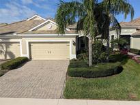 Charming single Gathering home with a tile roof, brick driveway, and a well manicured front lawn at 4830 Maymont Park Cir, Bradenton, FL 34203