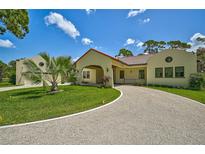 Spanish style home with circular driveway, mature landscaping, and attached garage at 360 N Point Rd, Osprey, FL 34229