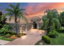 Luxury home exterior at sunset, featuring a tile roof and palm trees at 14215 Kinglet Ter, Lakewood Ranch, FL 34202