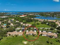 Aerial view of condo community near the water with tennis courts and pool at 684 Bird Bay W Dr # 132, Venice, FL 34285
