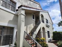 Inviting condo featuring stucco facade, red tile roof and beautiful stairway entrance at 7673 Fairway Woods Dr # 706, Sarasota, FL 34238