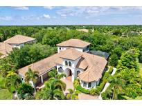 Beautiful aerial view of a home with a tile roof and a well-manicured, landscaped yard at 13215 Palmers Creek Ter, Lakewood Ranch, FL 34202