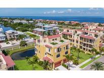 Stunning coastal home featuring a red tile roof, lush landscaping, and expansive ocean views from a rooftop terrace at 1450 Silvia Shores Dr, Apollo Beach, FL 33572