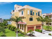 Charming multi-story home featuring a two-car garage and lush tropical landscaping at 1450 Silvia Shores Dr, Apollo Beach, FL 33572