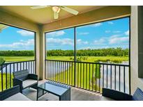 Enjoy the view of the lake and golf course from the screened-in balcony with comfortable seating area at 17704 Gawthrop Dr # 402, Bradenton, FL 34211