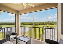 Spacious screened lanai with wicker furniture offering scenic golf course views at 17704 Gawthrop Dr # 402, Bradenton, FL 34211