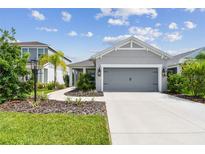 Gray house with gray garage door and landscaping at 10417 Crooked Creek Ct, Parrish, FL 34219