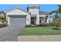 Two-story home with gray garage door, paved driveway, and landscaped lawn at 17931 Palmiste Dr, Bradenton, FL 34202