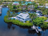 Aerial view of waterfront home with private dock and lush landscaping at 5727 Riegels Point Rd, Sarasota, FL 34242