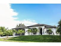 Modern home with two-car garage and manicured lawn at 11061 Sandrift Ave, Englewood, FL 34224