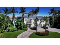 Two-story home with a metal roof, double door entry, and lush landscaping at 549 Sloop Ln, Longboat Key, FL 34228