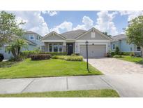 One-story home with gray siding, stone accents and a two-car garage at 5228 Bentgrass Way, Bradenton, FL 34211