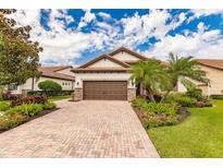 One-story home with brown garage door and landscaping at 4694 Royal Dornoch Cir, Bradenton, FL 34211