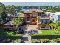 Stunning waterfront home featuring a manicured lawn, brick driveway and balconies overlooking the water at 1502 Siesta Dr, Sarasota, FL 34239