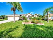 Landscaped front yard with lush grass and palm trees at 139 Long Meadow Lane Ln, Rotonda West, FL 33947