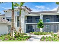 Beautiful two-story condo featuring screened lanais, well-maintained landscaping, and paver walkways at 17445 Opal Sand Dr # 104, Venice, FL 34293