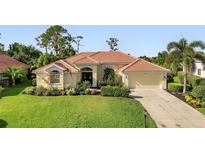 Charming single-story home with a well-manicured lawn and a welcoming double-door entrance, complemented by lush landscaping at 13791 Palmetto Point Ct, Port Charlotte, FL 33953