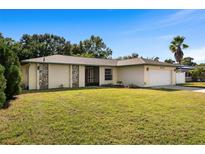 Ranch-style home with a well-maintained lawn and attached garage at 6743 2Nd Avenue W Cir, Bradenton, FL 34209