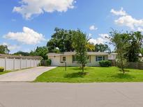 Ranch home with light yellow exterior, and a well-manicured lawn at 2717 Grove Pl, Sarasota, FL 34239