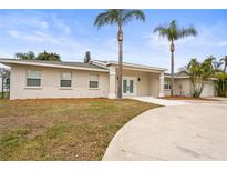 Charming single-story home with stucco and stone accents, palm trees, and a circular driveway at 2232 River Ridge Dr, Sarasota, FL 34239
