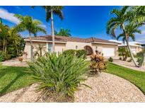 Single-story home with a two-car garage and tropical landscaping at 1200 Via Tripoli, Punta Gorda, FL 33950
