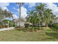 Tan house with a white garage door and landscaping at 7217 Churston Ln, University Park, FL 34201