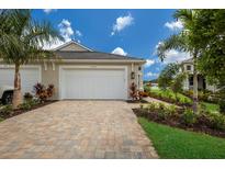 Two-car garage with paver driveway and tropical landscaping at 10748 Klee Ave, Bradenton, FL 34212