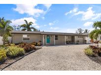 Single-story home with teal door and gravel driveway at 4108 101St W St, Bradenton, FL 34210