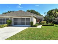 House exterior featuring a two-car garage and well-maintained landscaping at 4072 Fairway Pl, North Port, FL 34287