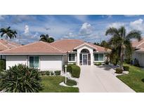 Single-story home with tile roof, landscaping, and driveway at 6772 Greenview Ln, Englewood, FL 34224