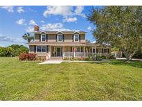 Two-story house with large front yard, porch, and mature trees at 1914 24Th W Ave, Palmetto, FL 34221