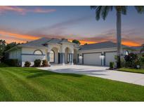 Beautiful single-story home with an attached three-car garage, a well-manicured lawn, and lovely landscaping at 15923 29Th E St, Parrish, FL 34219