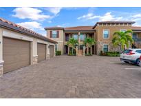 Two-story building with attached garages and palm trees at 12710 Sorrento Way # 101, Bradenton, FL 34211
