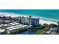 Beautiful aerial view of beachfront condos with covered parking, lush landscaping, and stunning ocean views at 19 Whispering Sands Dr # 204, Sarasota, FL 34242