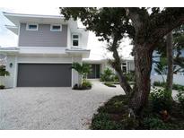 Modern two-story home with gray siding, white trim, and a gravel driveway at 4819 Higel Rd, Sarasota, FL 34242