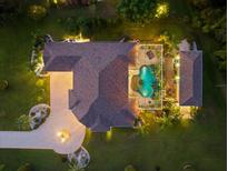 Overhead view of a home with a pool and landscaped yard, illuminated at night at 17812 Doe Creek Ct, Parrish, FL 34219