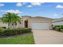 House exterior featuring a two car garage and manicured landscaping at 12642 Cara Cara Loop, Bradenton, FL 34212