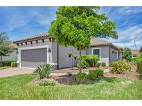Charming home featuring a well-manicured front yard and an attached two-car garage at 5732 Puccini St, Nokomis, FL 34275