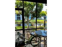 Enclosed patio with canal view, table, chairs and bicycle at 6033 34Th W St # 1, Bradenton, FL 34210