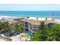 Beautiful multi-story beachfront property with lush landscaping, tiled roof, and ample parking at 1900 Gulf N Dr # 4, Bradenton Beach, FL 34217