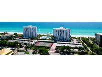 Aerial view of beachside property with tennis courts and pools at 1000 Longboat Club Road # 1103, Longboat Key, FL 34228