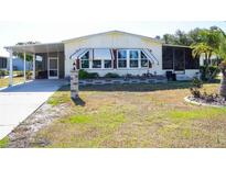 Single-wide mobile home with carport and landscaping at 6064 Shearwater Dr, Englewood, FL 34224