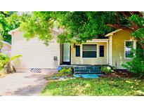 Charming single-story home with light yellow siding, an ADT security system, and a lush tree-lined front yard at 5415 5Th N Ave, St Petersburg, FL 33710