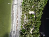 Aerial view of waterfront property with beach access and lush landscaping at 8440 Sanderling Rd, Sarasota, FL 34242