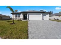 New construction home with a three-car garage and paved driveway at 223 Rio De Janeiro Ave, Punta Gorda, FL 33983