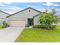 Single-story house with two-car garage and landscaping at 654 Ocean Spray Dr, Ruskin, FL 33570