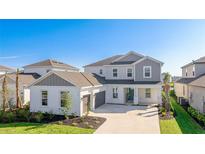 Two-story home showcases a white exterior, gray accents, well-manicured lawn, and an attached two-car garage at 9478 Tequila Sunrise Dr, Sarasota, FL 34241
