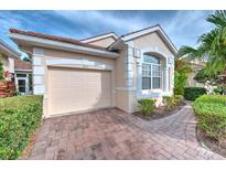 House exterior showcasing a tan color scheme, and brick paver driveway at 7823 33Rd E St # 20, Sarasota, FL 34243