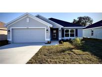 Modern two-car garage home with gray exterior and landscaped lawn at 2620 Averland Loop, North Port, FL 34287